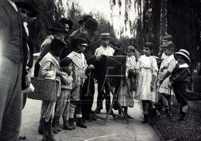 Pastore, Vincenzo. Grupo de pessoas ao redor de realejo, na praça da República. Praça da República. São Paulo. SÃO PAULO / Brasil. 1910 circa.